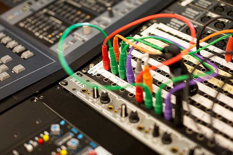 Colorful cables plugged into a soundboard