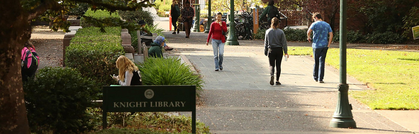 Students walking on campus near Knight Library