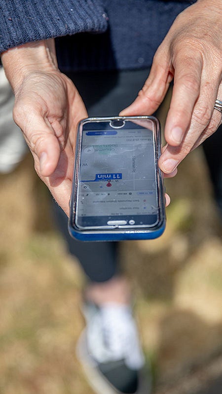 Hands holding a cellphone showing a map on the screen