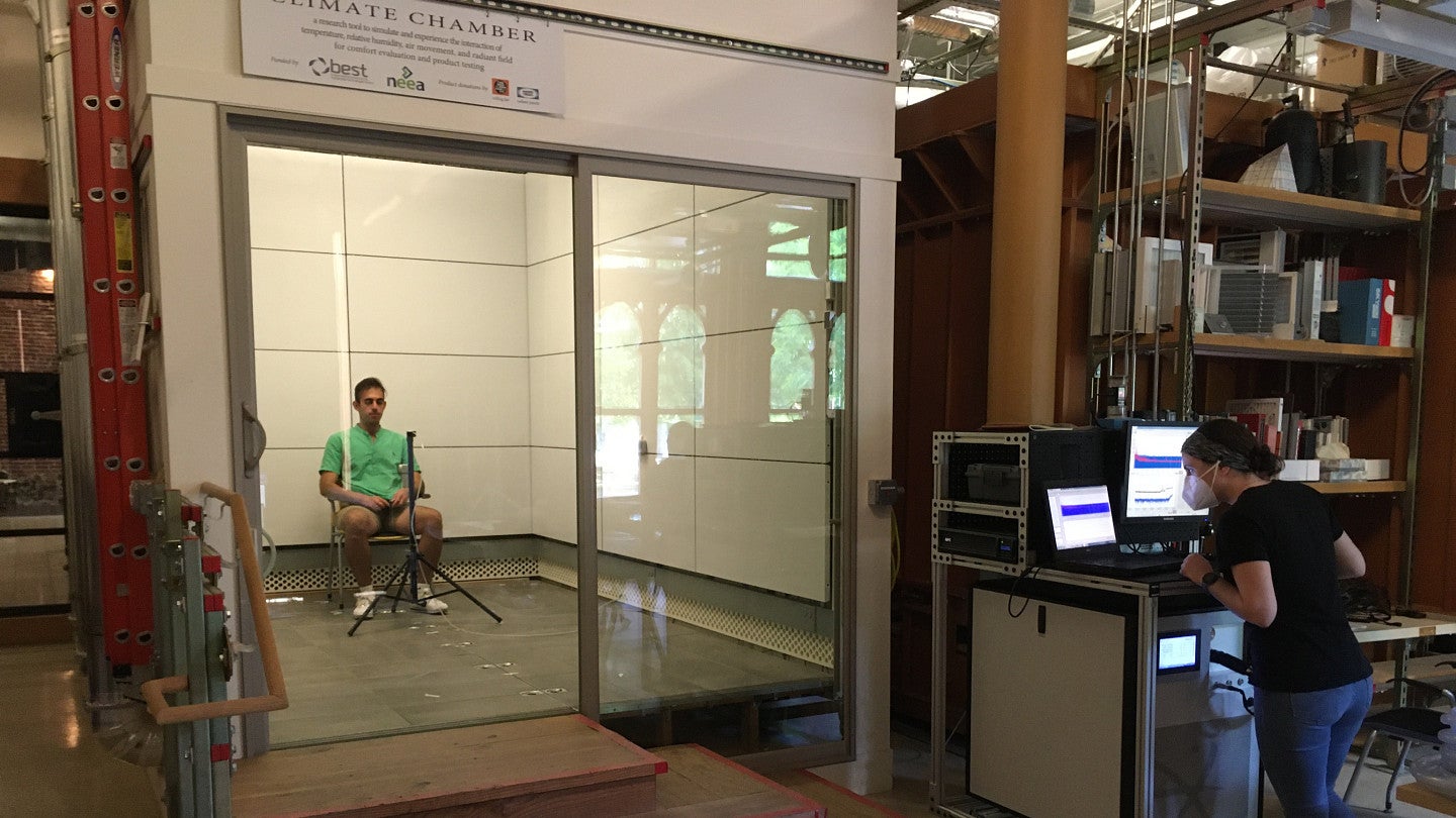 Research subject sitting inside climate chamber.