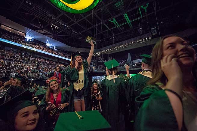Student waves to the crowd looking for family members Student waves to the crowd looking for family members