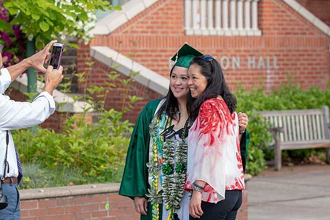 Families are all smiles taking photos with their graduates Families are all smiles taking photos with their graduates