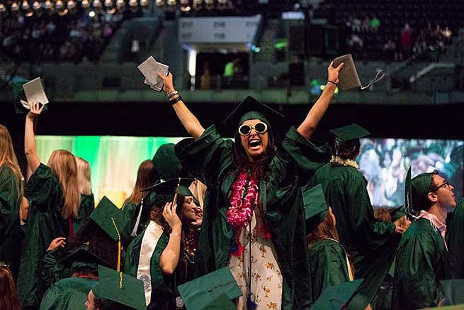 Student cheers in the crowd of graduates Student cheers in the crowd of graduates