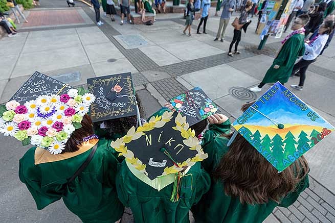 Four students show off their decorated graduation caps Four students show off their decorated graduation caps