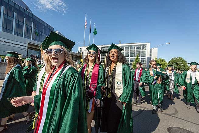Students cheer for the camera before walking into the stadium for graduation Students cheer for the camera before walking into the stadium for graduation