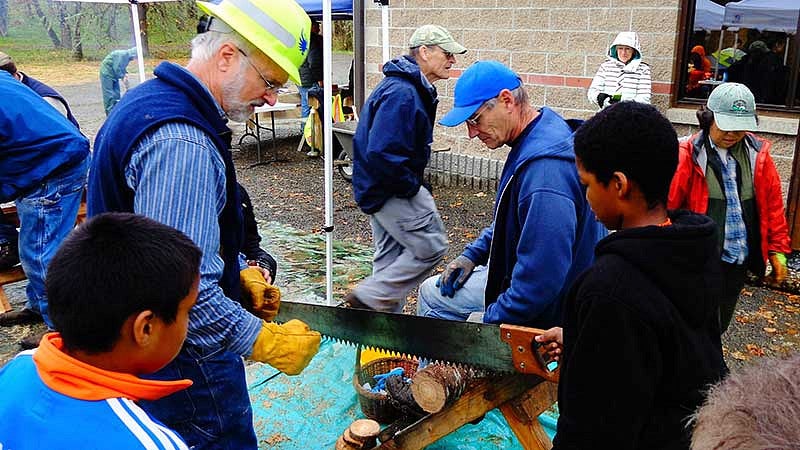 Student sawing through a log