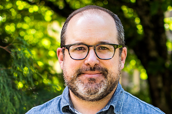 David Ewald pictured in front of a bright green plant-filled background