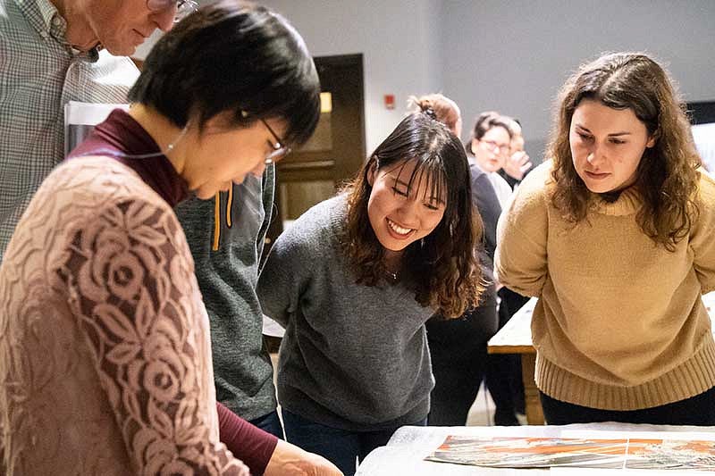 Three people looking at a drawing on a table