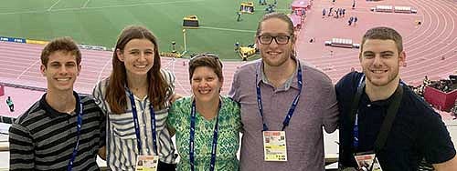 Group photo of SOJC students with a backdrop of the track in Doha