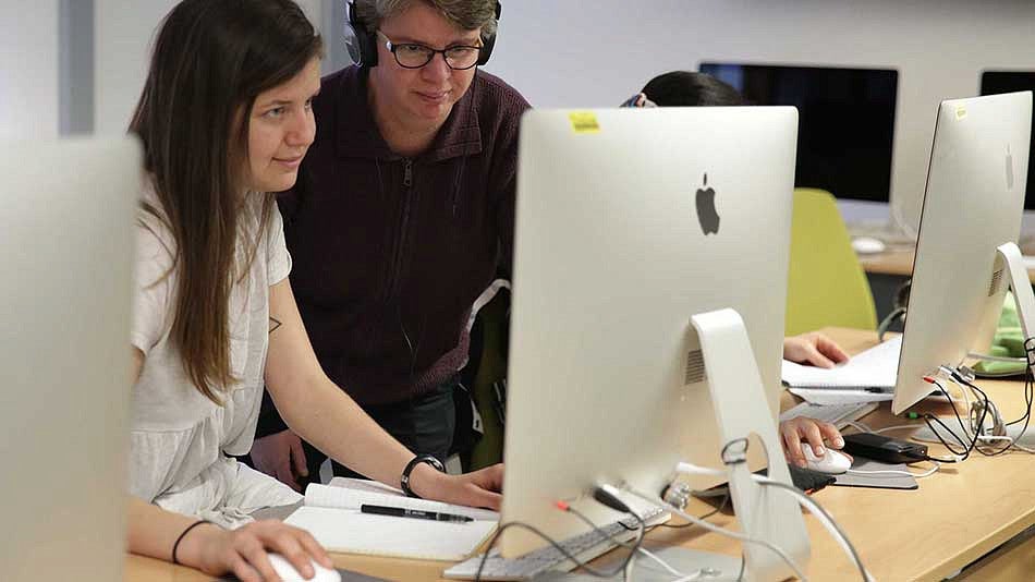 Gabriela Martinez working at a computer with a student