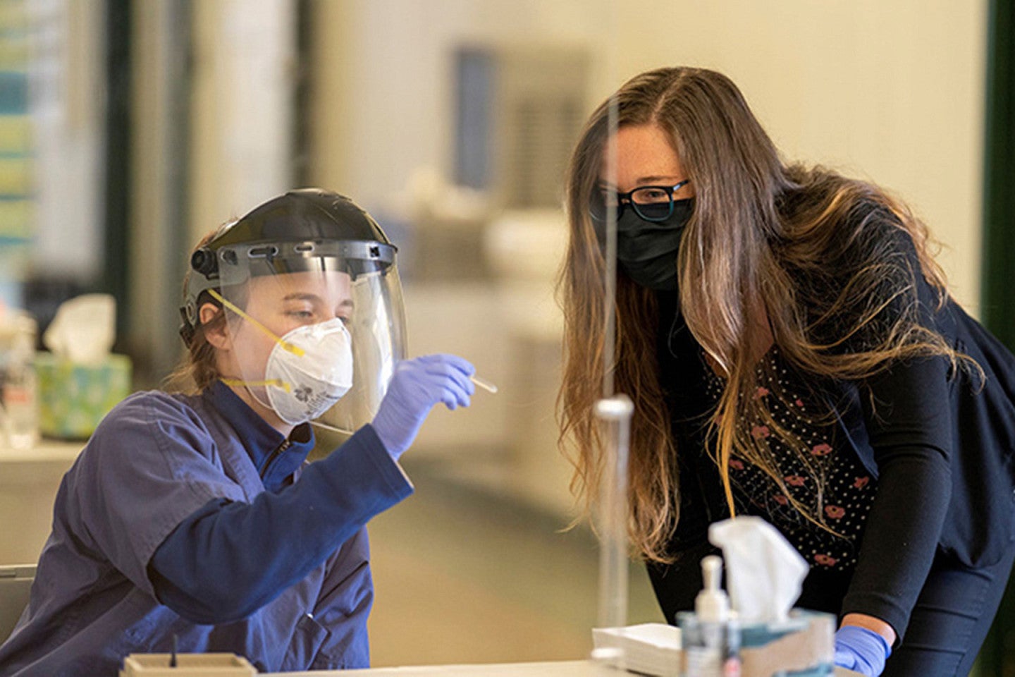 Hannah Tavalire administering COVID saliva-swab test to a client.