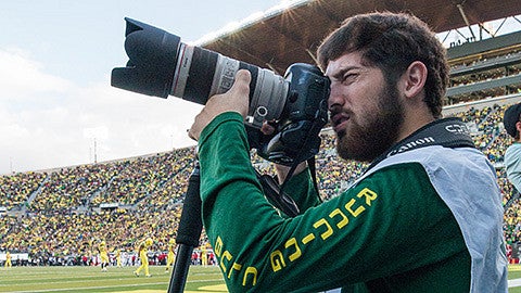 Justin Hartney shooting photos at an Oregon football game