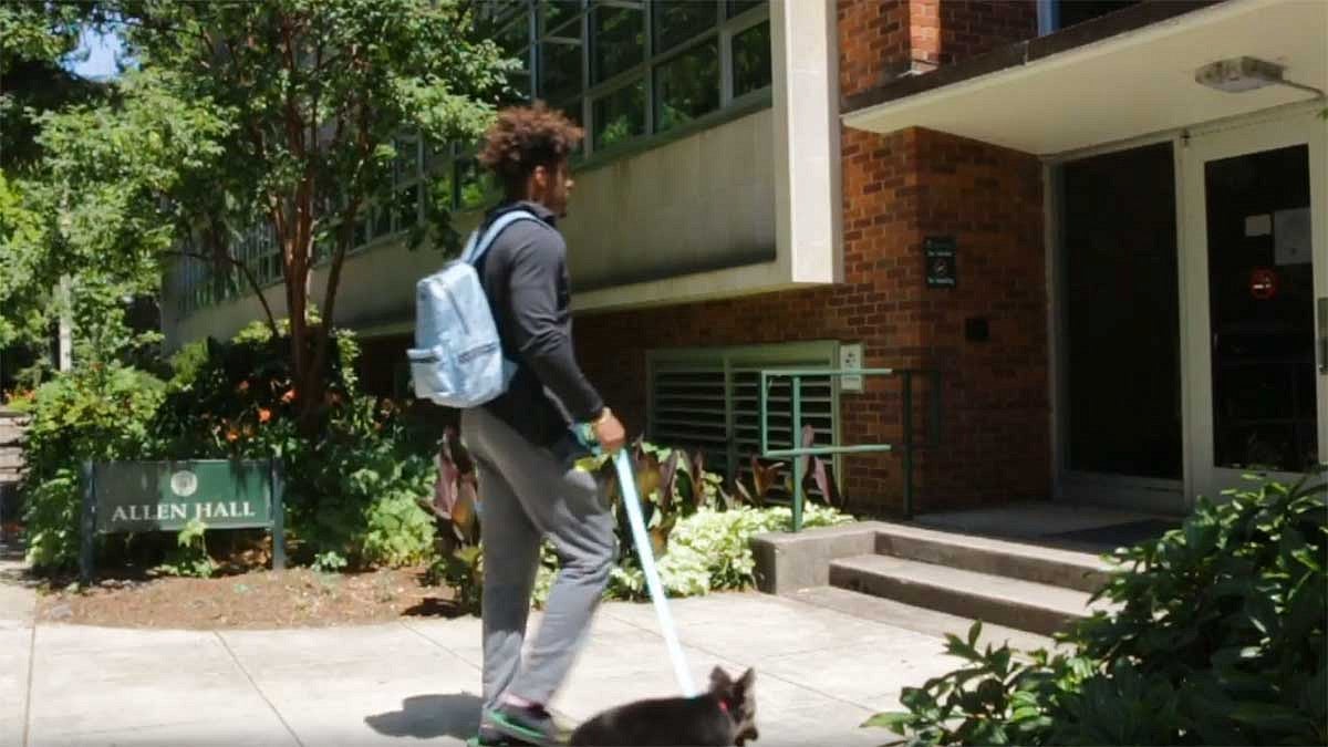 Kayvon Thibodeaux walking into Allen Hall, home of the Schoo of Journalism and Communication