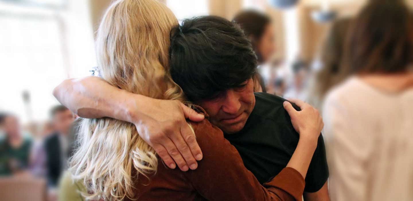 Juan Camacho hugging a woman a the Latino Roots Celebration