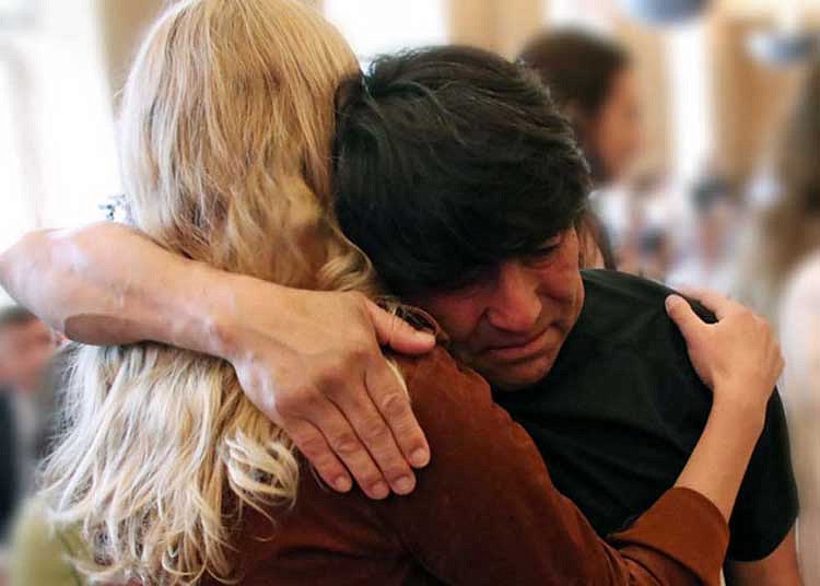 Juan Camacho hugging a woman a the Latino Roots Celebration