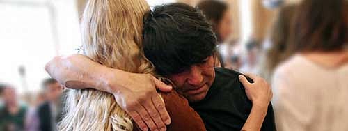 Juan Camacho hugging a woman a the Latino Roots Celebration