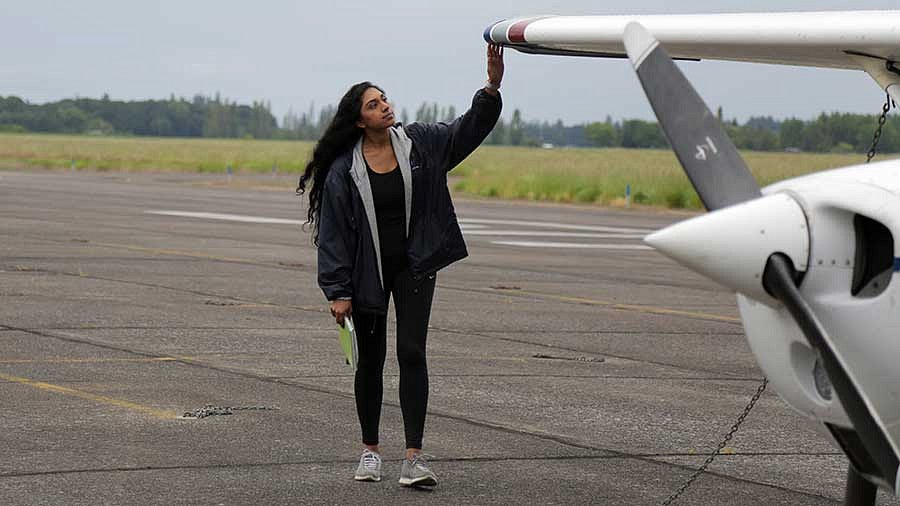 Manju Bangalore going through preflight checks outside an airplane