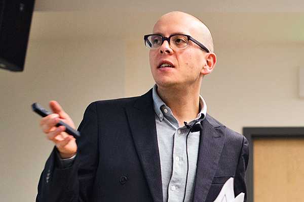 Max Foxman gestures to a screen during class