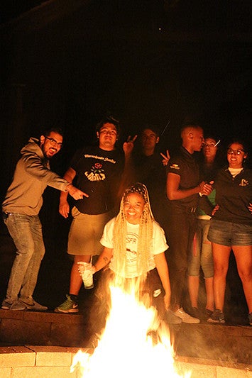 students gathered around a camp fire at the 2018 New Student Fall Retreat