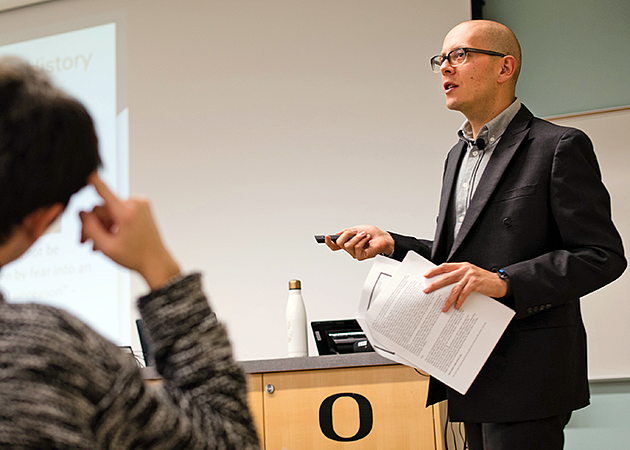 Max Foxman gestures to a screen during class