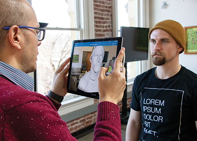 SOJC professor Max Foxman uses an ipad to make a 3d scan of a student's face