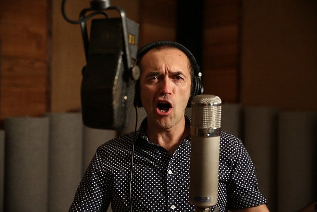 Steve Perry in the recording studio singing at a microphone