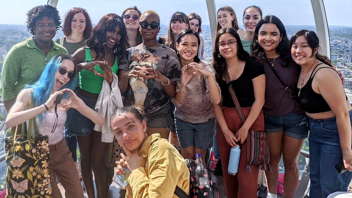 students in london making the o shape with their hands