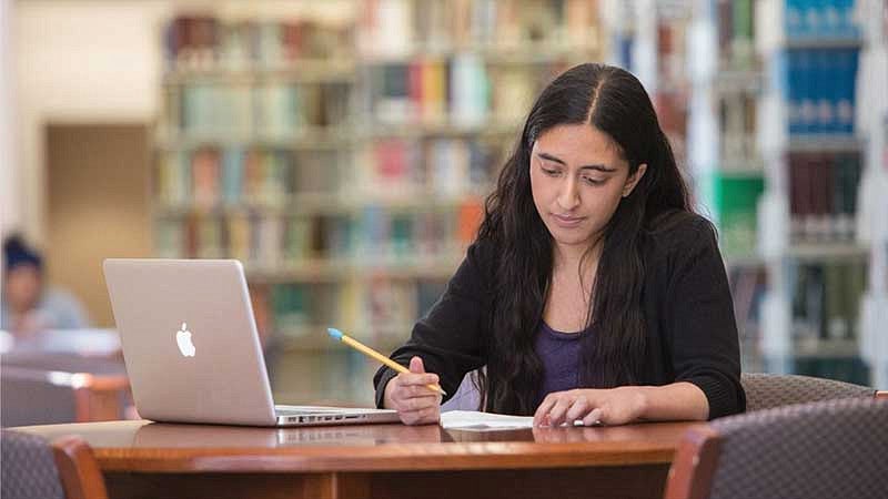 Womean working at a table in a library