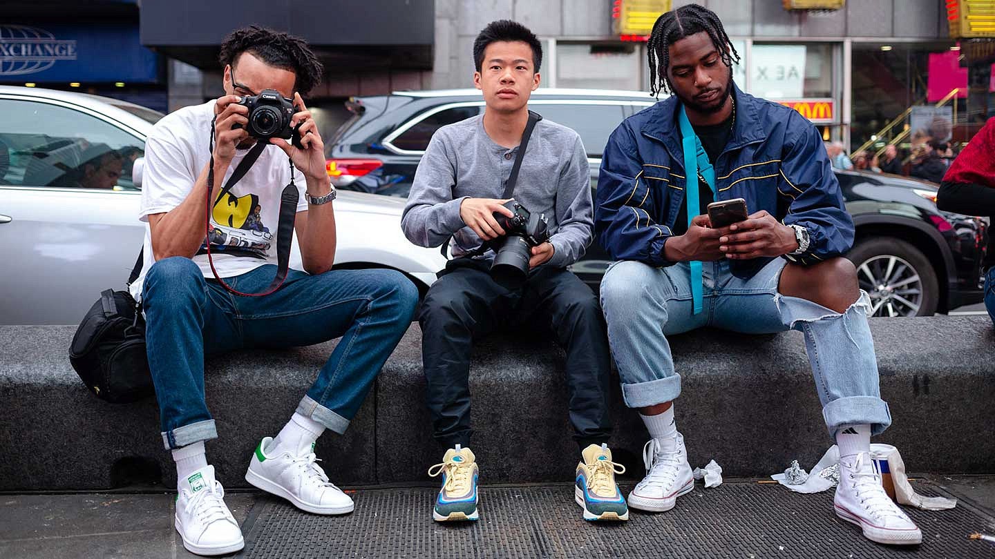 UO SOJC stuents Scotty Williams II, Ryan Hus, Duane Harris sitting on a curb with camera equipment