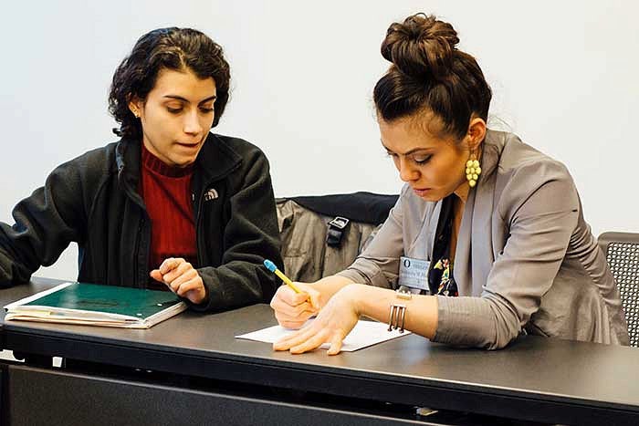 Two female students talking at a table