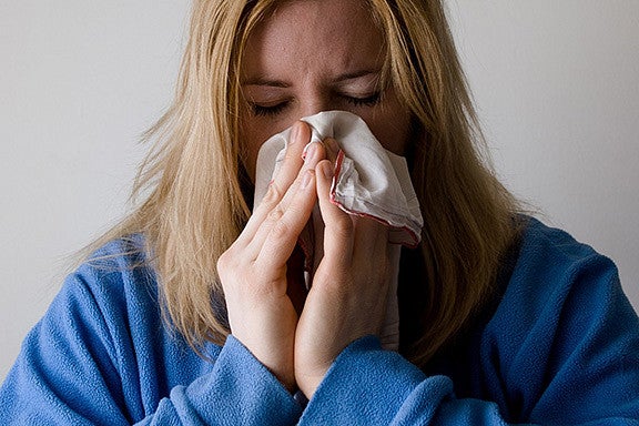 woman blowing her nose into a handkerchief