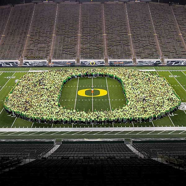 Students in the Class of 2023 form the O on the field at Autzen Stadium