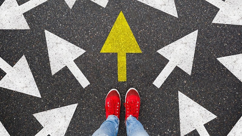 Woman standing on street painted with arrows