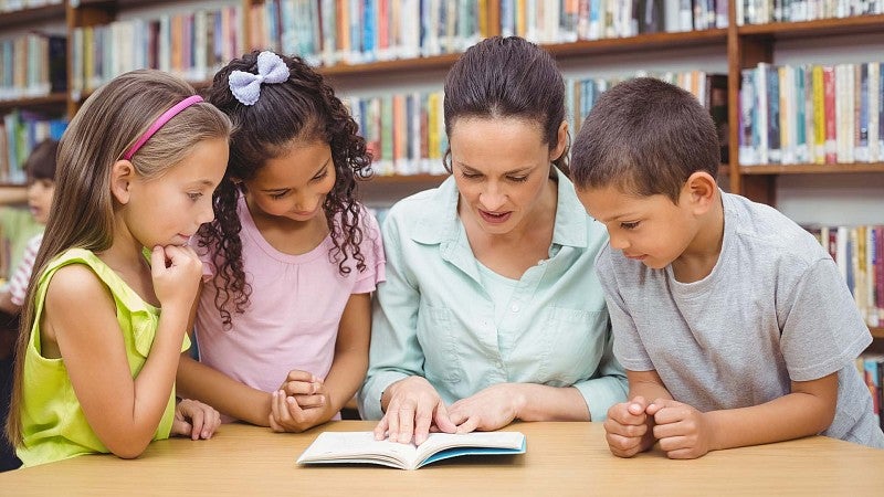 Kids reading with teacher