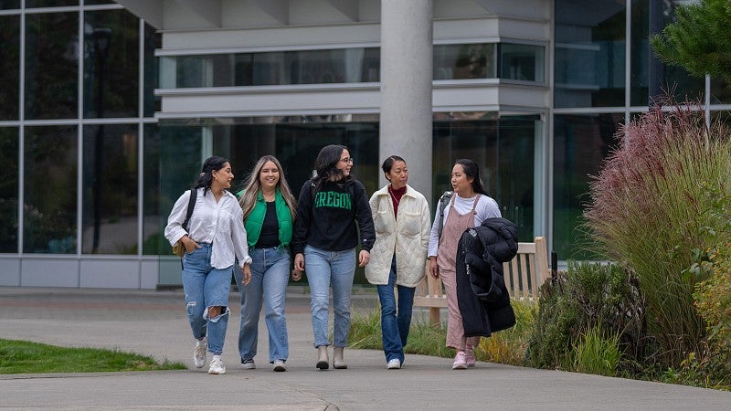 Students walking in front of the Teaching Center on the UO Portland campus