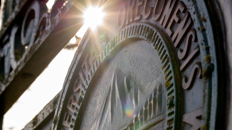A sunburst behind the Great Seal of the university at Dads' Gates evokes the promise of the new UO strategic goals