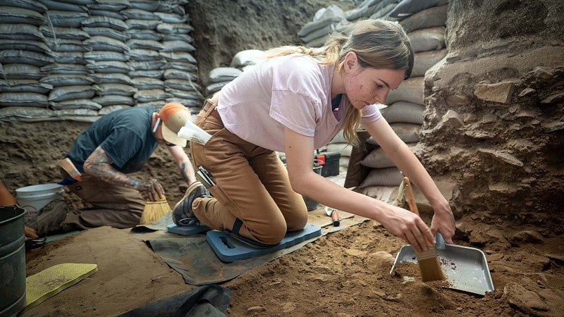 Gabi Gauthier scrapes a dirt layer from the Connley Caves dig