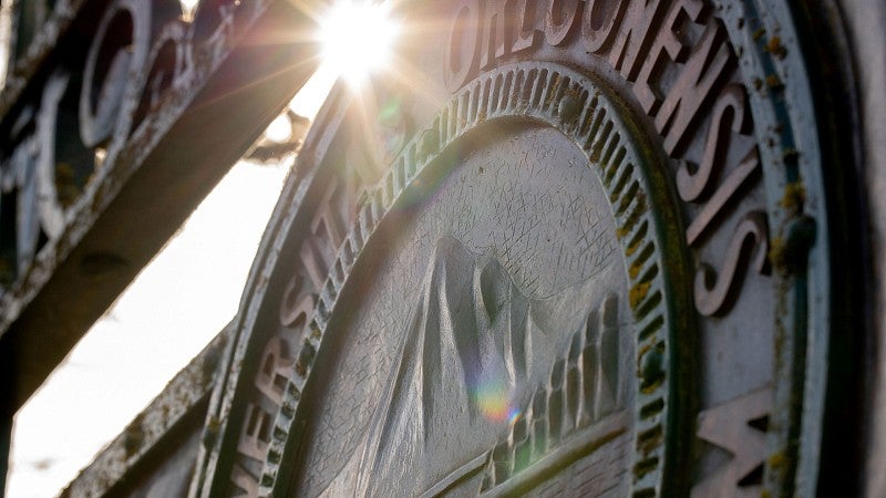 The Great Seal of the UO on Dad's Gate with sun shining through it