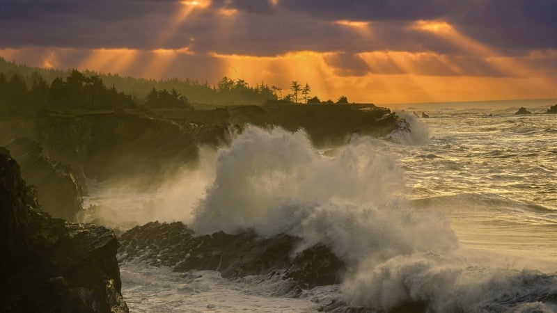 A smoke filled sky as seen through the pounding waves on the Oregon coast.