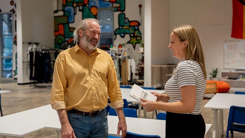 A male architect a female nonprofit executive that serves youth talk inside the nonprofit's colorful facility.