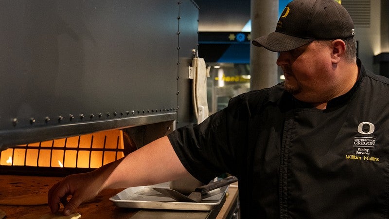 UO Chef William Mullins using oven at Pacific Northwest Market in Unthank Hall