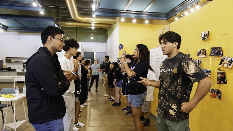 A group of students facing each other get acquainted during an icebreaker exercise.