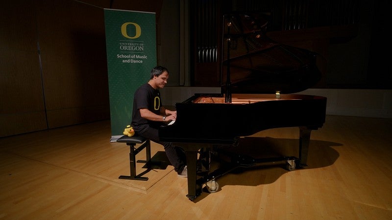 Grad student Ciro Magnani playing 'Mighty Oregon' on piano