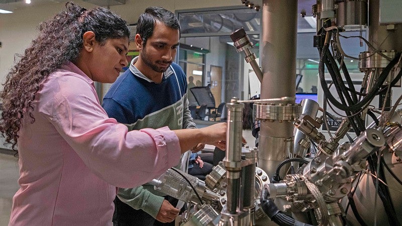 Researchers using a high-tech instrument in the Surface Analytical Lab