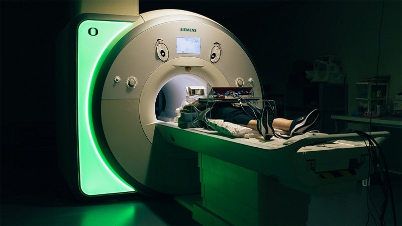 Test subject lying on table outside an MRI machine