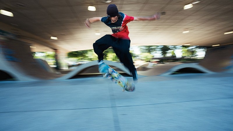 Teen doing stunts at a skateboard park