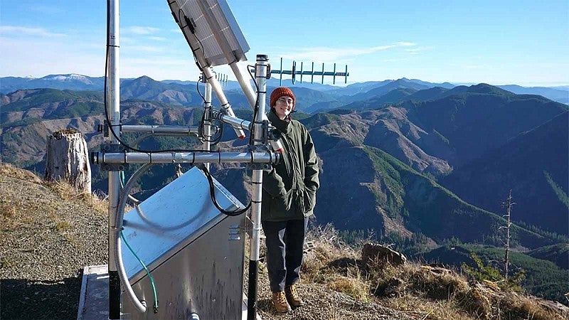 Sidney Whiting standing next to a ridgetop monitoring station