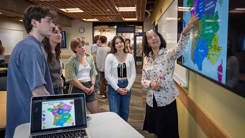 A teacher looking at wall map with students