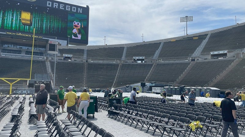 Volunteers cleaning up the filed after a commencement ceremony.