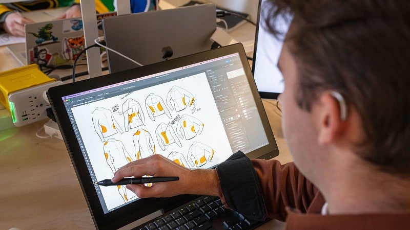 Student designing clothing on a tablet